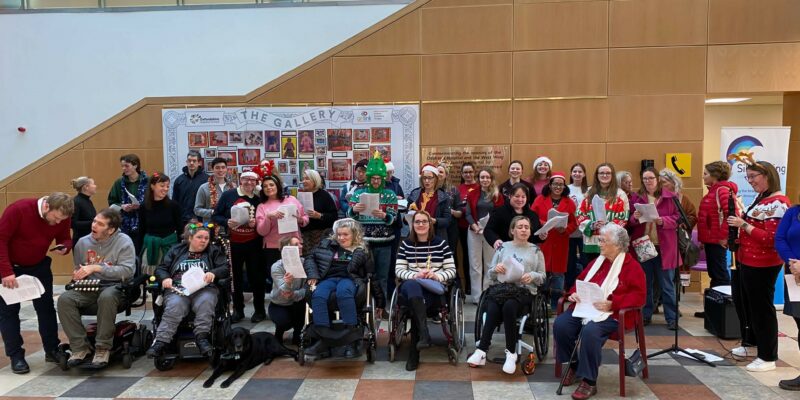 A group of people singing carols with Silverlining at the John Radcliffe Hospital