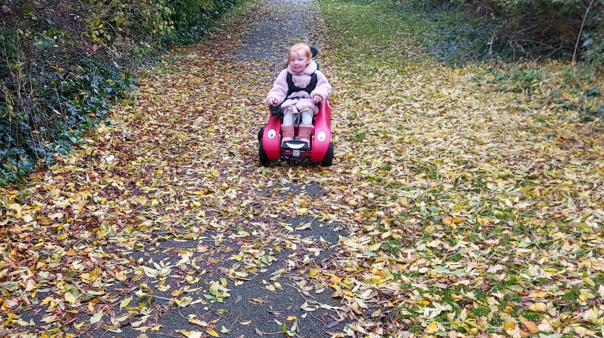 Lily in her Wizzybug in autumn
