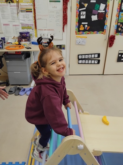 young happy girl enjoying a new toy at the rainbow centre