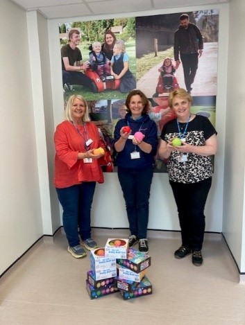 A group of ladies from team Wizzybug holding the sensory toys, sponsored by CL Medilaw.