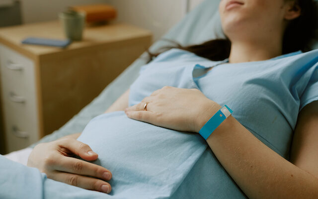 pregnant mum worried about hie grades rubs tummy