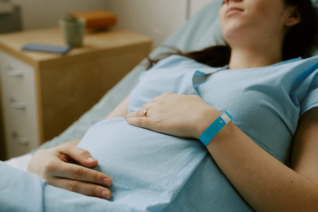pregnant mum worried about hie grades rubs tummy