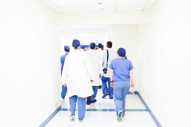 surgeons walking away from camera down a white corridor, highlighting the theme of patient safety incidents nhs