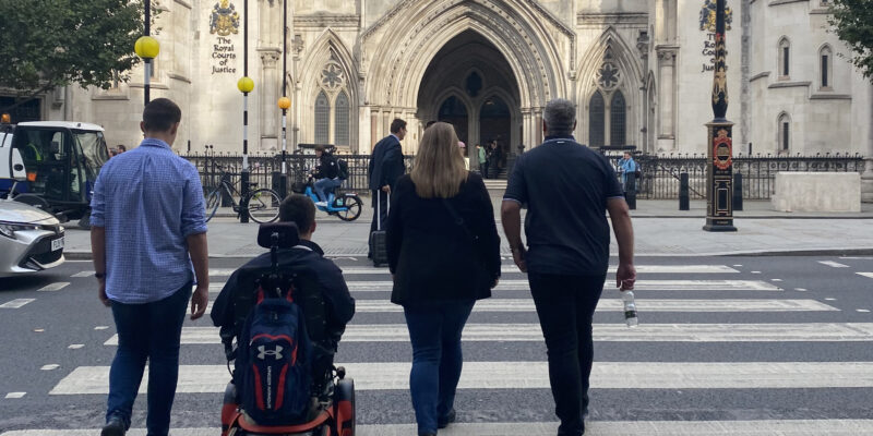 Photo of RXZ and his family crossing a zebra crossing as they head into the Royal Courts of Justice for their settlement hearing.