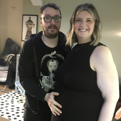 Tom and Rebecca proudly holding her bump